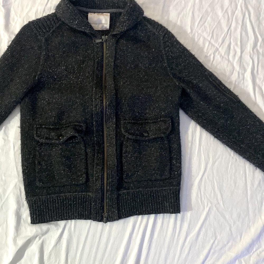 heavy jacket has 2 button pockets and a zipper pocket on the left arm